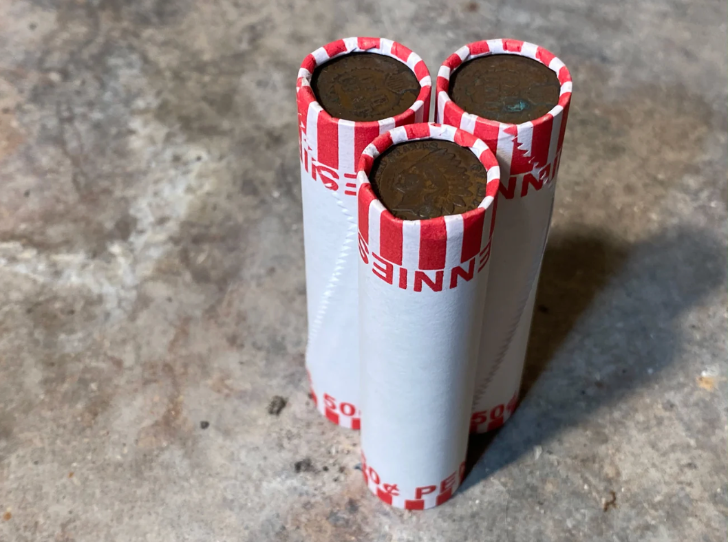 INDIAN HEAD CENT showing on one end of old unsearched white us wheat penny roll
